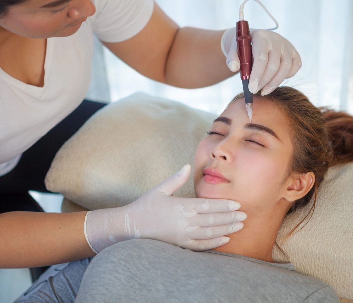 141 (1) A woman receiving a cosmetic injection on her forehead at a clinic.