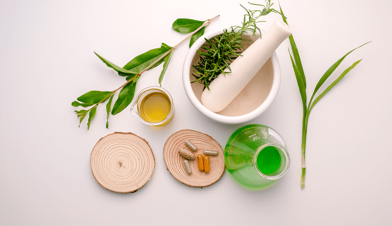 GettyImages-1170207585 Herbs, a mortar and pestle, and natural oils arranged for herbal preparation.