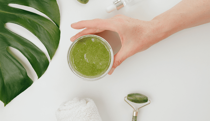 GettyImages-1499002642 Hand holding a green smoothie in a clear glass.