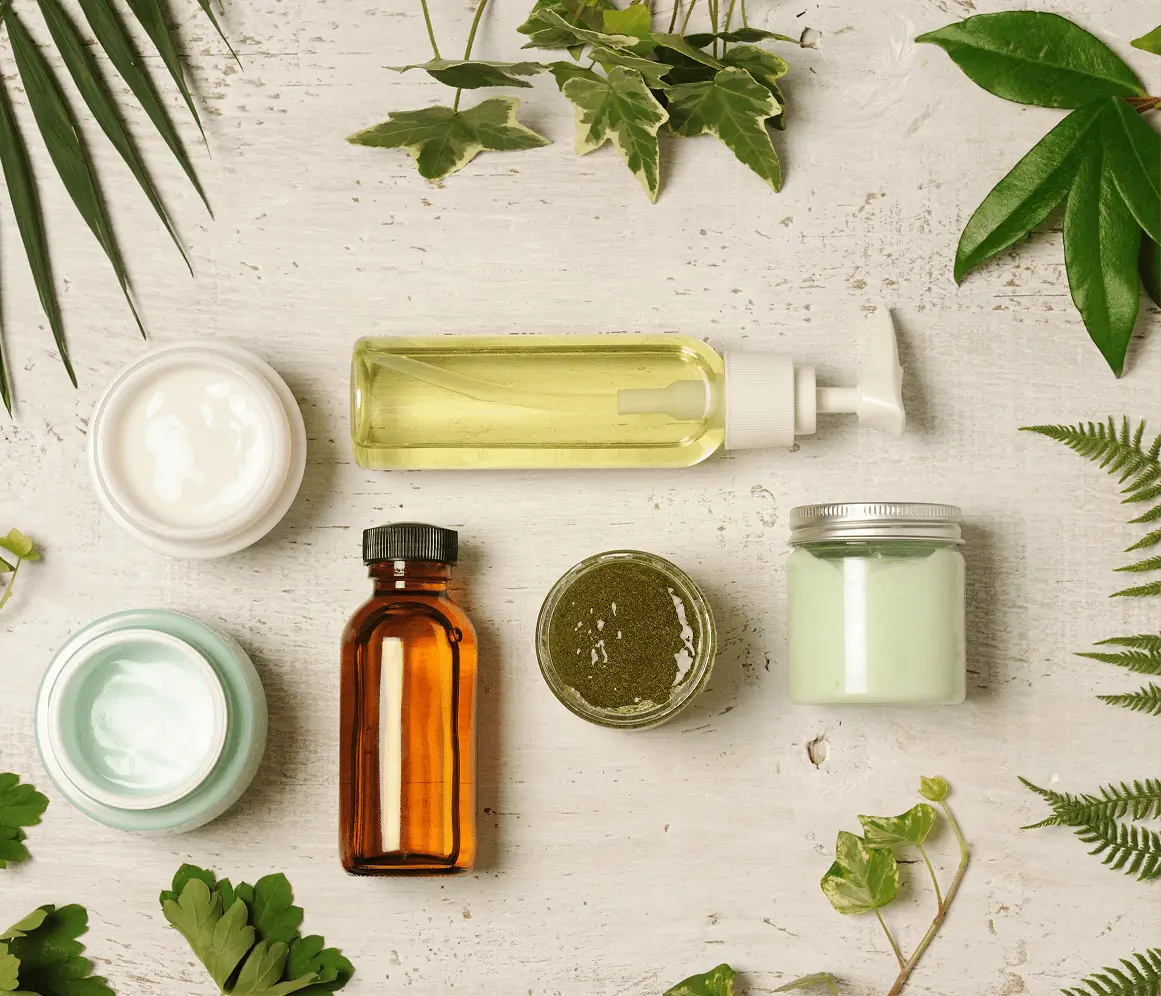 Natural skincare products with plant ingredients on a wooden surface.